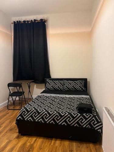 a bedroom with a bed and a black curtain at 3 Bedroom Apartment in London