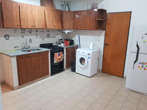 a kitchen with a washing machine and a washer at La esquina - Alquiler temporario in Santa Rosa