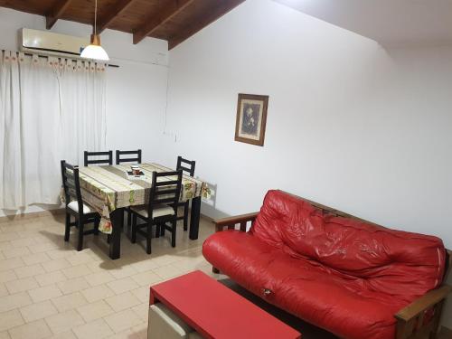 salon z czerwoną kanapą i stołem w obiekcie La esquina - Alquiler temporario w mieście Santa Rosa