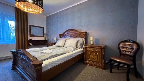 1 dormitorio con 1 cama, 1 silla y 1 lámpara de araña en Center House, en Dunaújváros