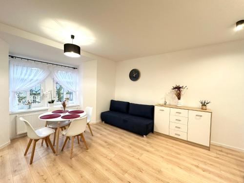 a living room with a blue couch and a table at Apartament SASANKA in Kudowa-Zdrój