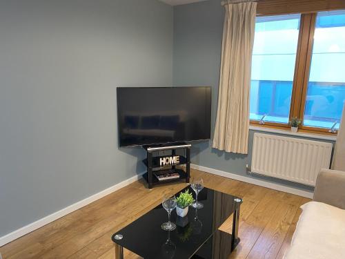 uma sala de estar com uma televisão de ecrã plano e uma mesa em May Disc - Long Stay - Contractors em Bristol