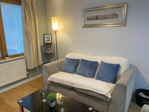 ein Wohnzimmer mit einem Sofa mit zwei blauen Kissen in der Unterkunft May Disc - Long Stay - Contractors in Bristol