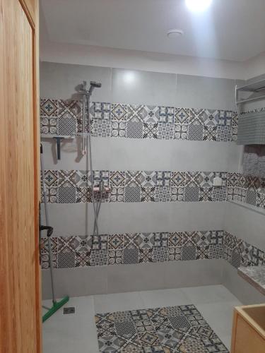 baño con ducha con azulejos en la pared en Gîte Forest Kasbah, en Kasba et Tahar