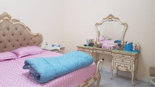 a bedroom with a bed and a vanity with a mirror at لايجار ٢ غرفه وصاله باقاسميه الشارقه in Sharjah