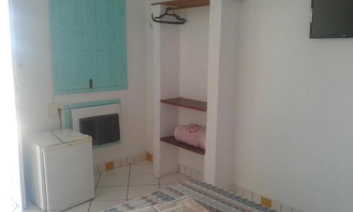 a small kitchen with a refrigerator and a window at Pousada Vista Bela in Arraial d'Ajuda