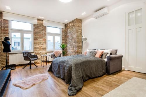 um quarto com uma cama e uma parede de tijolos em Luxurious Danubeside Apartment for 4 em Budapeste