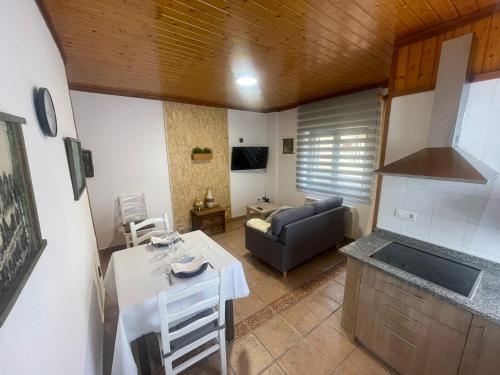 cocina y sala de estar con mesa y sofá en Casa Rural Peñas II, en Saucelle