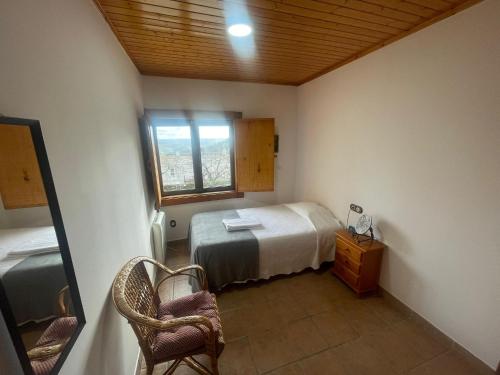 a small bedroom with a bed and a window at Casa Rural Peñas II in Saucelle