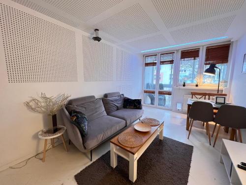 ein Wohnzimmer mit einem Sofa und einem Tisch in der Unterkunft Scandinavian Retkinia Distric in Łódź