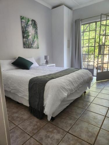 - une chambre avec un lit et une grande fenêtre dans l'établissement Peace of Nature, à Bloemfontein