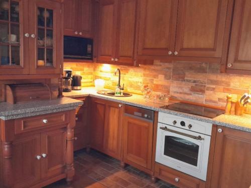 cocina con armarios de madera y horno de fogón blanco en zámek Nemilkov en Velhartice