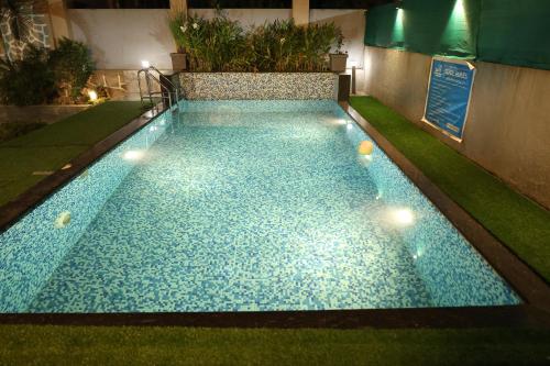 una piscina con luces en el césped en Shalimar Royal Villa, en Lonavala
