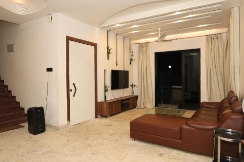 sala de estar con sofá y TV en Shalimar Royal Villa, en Lonavala