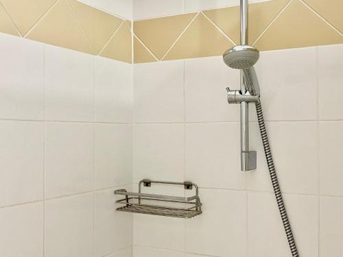 La salle de bains est pourvue d'une douche et de carrelage blanc. dans l'établissement Loft Berberis, château XVe, Dinan, à Taden