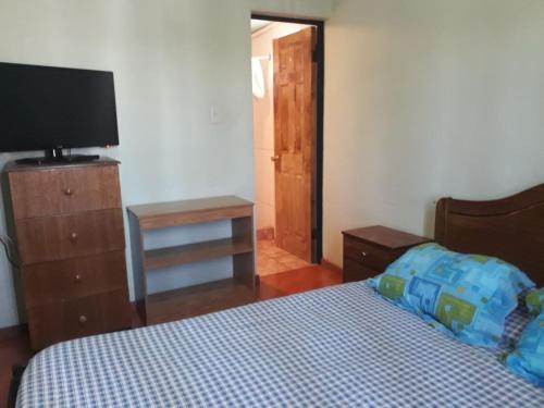 1 dormitorio con 1 cama y TV de pantalla plana en Hostal vivar, en Calama