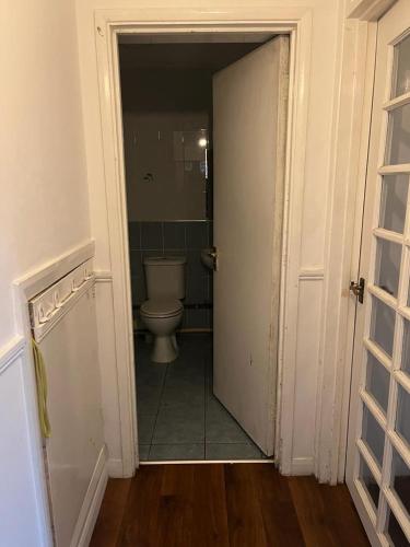 una puerta abierta a un baño con aseo en Dagenham Budget House, en Dagenham