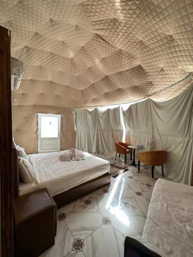 a bedroom with two beds and a wall with a ceiling at Nasem rum in Wadi Rum