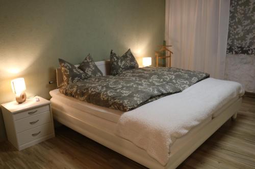 a bedroom with a bed with a nightstand and two lamps at Ferienwohnung Lohrenz in Goslar