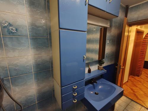a bathroom with a sink and blue tiled walls at Apartment Prešeren in Smarjeske Toplice