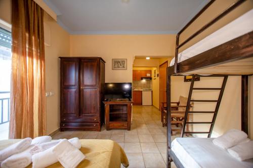 a bedroom with two bunk beds and a kitchen at Xenia Palace luxury apartments in Nea Vrasna