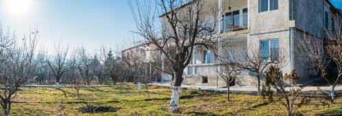 a building in a field with trees in front of it at Garni Nature Villa in Garni