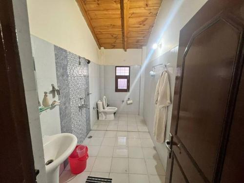 y baño con aseo, lavabo y ducha. en Alan's cottage, en Bhowāli