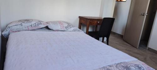 een slaapkamer met een bed met een tafel en een stoel bij Comodo Aparata estudio in Medellín