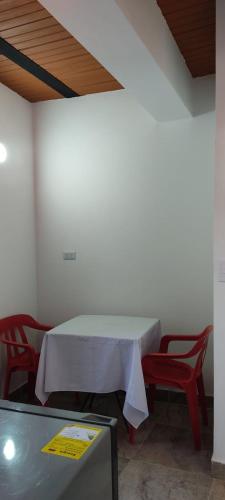 een kamer met een witte tafel en twee rode stoelen bij Comodo Aparata estudio in Medellín