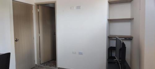 een hal met een deur naar een kamer met een tafel en stoelen bij Comodo Aparata estudio in Medellín