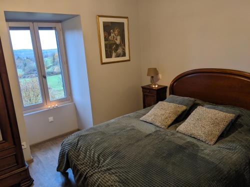 una camera da letto con un letto con due cuscini e una finestra di Manoir du Boscau, Gilles del Bosc a Prudhomat