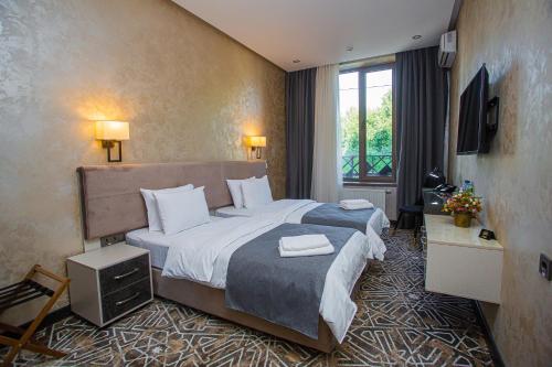 a hotel room with a large bed and a window at Florence Boutique Hotel by Hotel Pro group in Yakkasaray