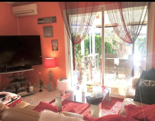 ein Wohnzimmer mit einem Sofa und einem großen Fenster in der Unterkunft Villa Piscine Mer 66 in Saint-Laurent-de-la-Salanque