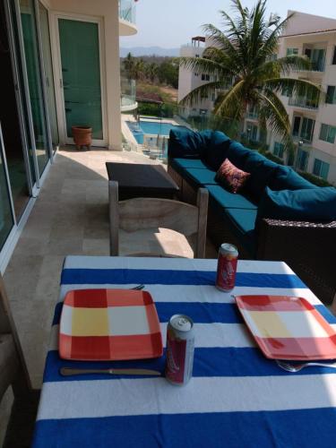 two tables with plates and cups on a patio at Perfectly located spacious apartment with 2 balconies in Ixtapa