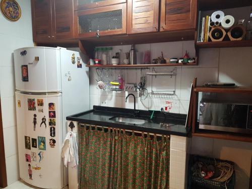 a kitchen with a sink and a refrigerator at Casa Cultural Caiçara Paraty - WiFi, Vaga privativa, próxima ao Centro Histórico in Paraty