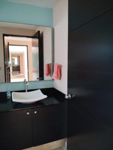 a bathroom with a sink and a mirror at Perfectly located spacious apartment with 2 balconies in Ixtapa
