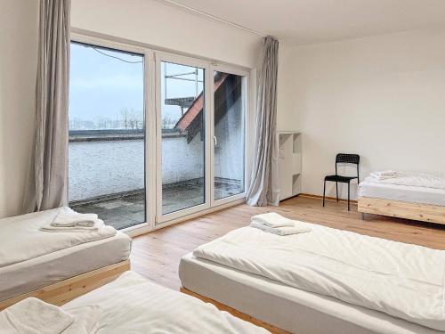 a bedroom with two beds and a large window at T&K Apartments - 3 - 5 Group Room Apartments- 15min to Fair DUS in Neuss