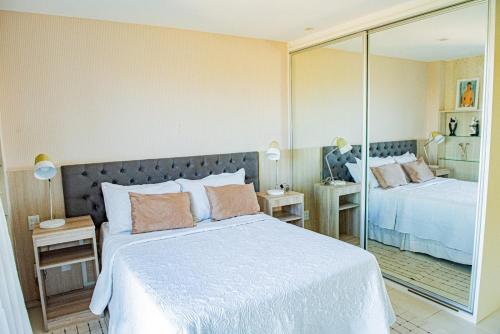 a bedroom with two beds and a mirror at Condominio Iberostate in Praia do Forte