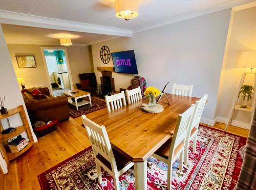 a living room with a wooden table and chairs at Gorwel, Spacious 3 Bedroom Cottage near the Beach in Llanarth
