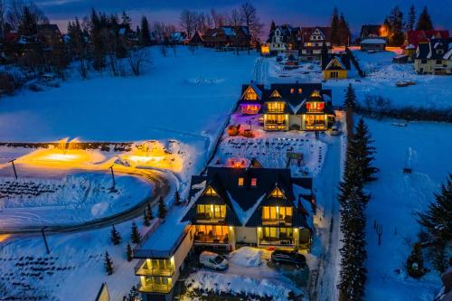 an aerial view of a house in the snow at night at Tybet Domki i Apartamenty in Bukowina Tatrzańska