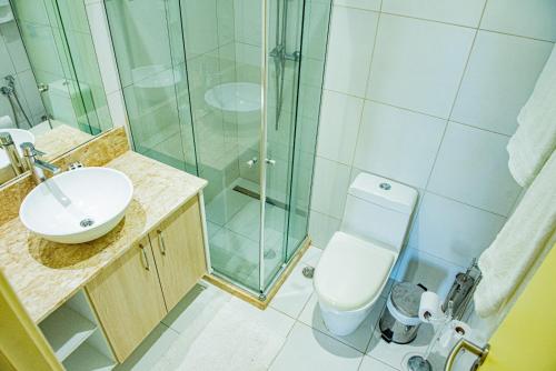 a bathroom with a shower and a toilet and a sink at Condominio Iberostate in Praia do Forte