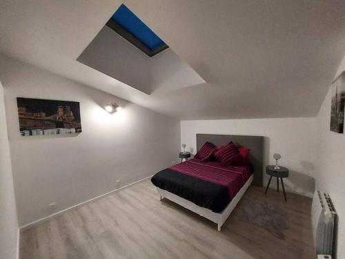 ein Schlafzimmer mit einem Bett und einem Dachfenster in der Unterkunft Appartement en duplex A113 in Draveil