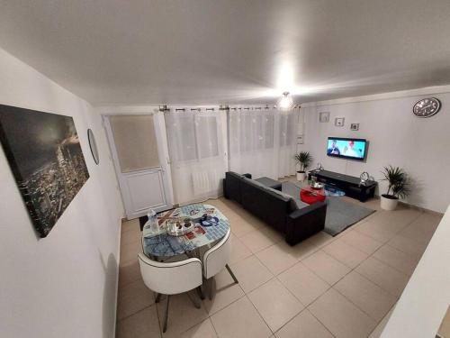 ein Wohnzimmer mit einem Sofa und einem Tisch in der Unterkunft Appartement en duplex A113 in Draveil