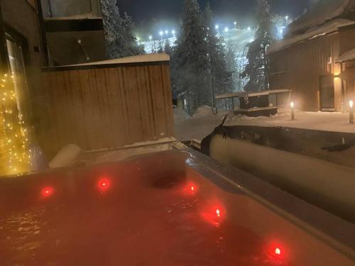 bañera con luces rojas en la nieve en Luxury Ski-in&Out &Private Jacuzzi (Levi Diamonds), en Sirkka