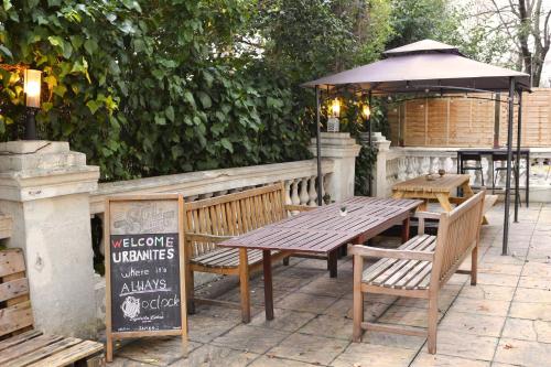 a wooden table and benches with an umbrella at Urbany Hostel London 18-40 Years Old in London