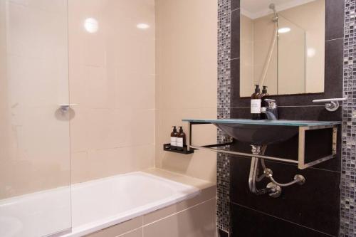 uma casa de banho com um lavatório, um chuveiro e uma banheira em Malvon Beautiful Suite em Buenos Aires