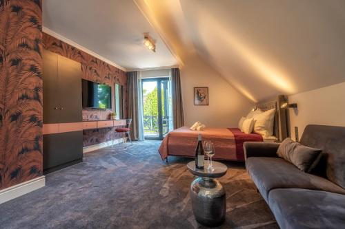 a hotel room with a bed and a couch at Villa Viktória in Balatonfüred
