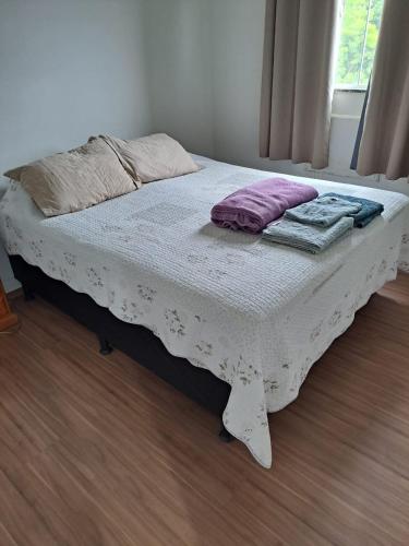 a bed with two pillows on it in a room at Margaça Condomínio Califórnia in Rio de Janeiro