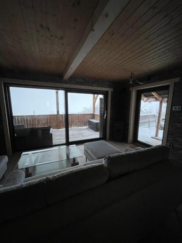 a living room with a couch and a large window at Mały Domek & Chatka Panorama in Lipowa