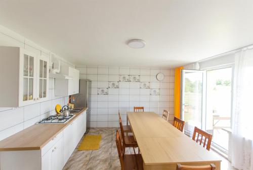 a kitchen with a long wooden table and chairs at Dom Korsarza in Mikołajki